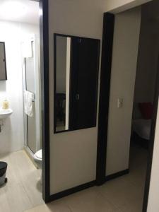 a bathroom with a door with a mirror and a toilet at ALOJAMIENO CERCA A UKUMARI, CONSOTA, EXPOFUTURO in Pereira