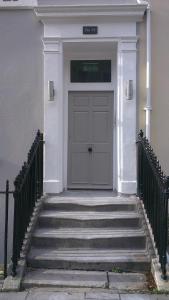 eine Eingangstür eines weißen Hauses mit Treppen in der Unterkunft Captain's Quarters by Pureserviced in Plymouth