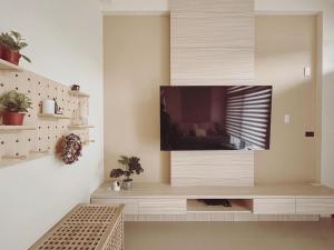 sala de estar con TV de pantalla plana en la pared en 禾樂號Hello House, en Luodong