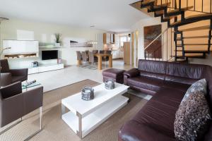 a living room with a couch and a table at Kapitänshaus Roseney in Norderney