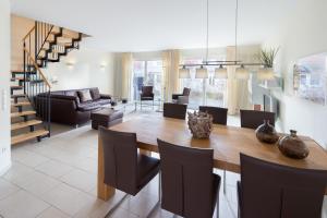 a dining room and living room with a table and chairs at Kapitänshaus Roseney in Norderney