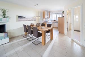 a kitchen and dining room with a table and chairs at Kapitänshaus Useney in Norderney +8 photos