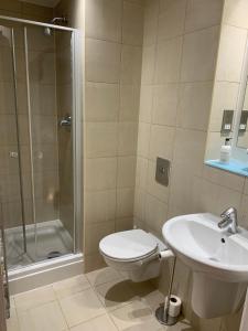 La salle de bains est pourvue de toilettes, d'une douche et d'un lavabo. dans l'établissement Modern, City Centre, Studio Apartment with FREE WIFI, GYM ACCESS, NETFLIX - West One, à Sheffield
