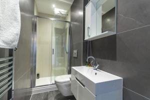 a bathroom with a toilet and a sink and a shower at The Windsor Suite in Plymouth