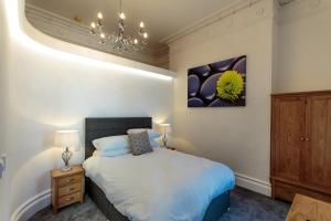 - une chambre avec un lit et un lustre dans l'établissement The Windsor Suite, à Plymouth
