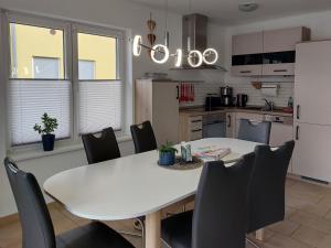 a kitchen with a white table and black chairs at Ferienhaus Meier in Wesenberg