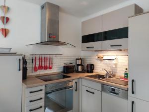 a kitchen with white cabinets and a stove top oven at Ferienhaus Meier in Wesenberg