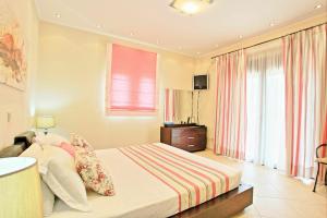 A bed or beds in a room at Acharavi Beach Villa by PosarelliVillas