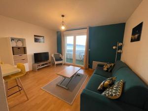 uma sala de estar com um sofá verde e uma mesa em Bagnu di sole - sur la route des îles sanguinaires adorable T2 vue mer em Ajaccio
