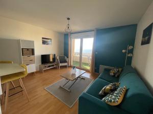 uma sala de estar com um sofá verde e uma janela em Bagnu di sole - sur la route des îles sanguinaires adorable T2 vue mer em Ajaccio