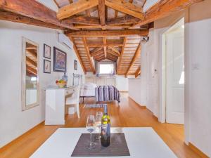 una sala de estar con techos de madera y una mesa con copas de vino en Heritage Hotel Villa Valdibora, en Rovinj