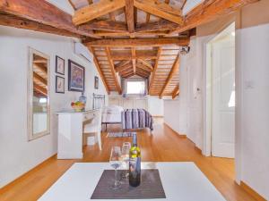 a living room with wooden ceilings and a table with wine glasses at Heritage Hotel Villa Valdibora in Rovinj