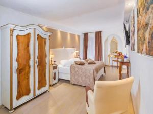 um quarto com uma cama, uma mesa e uma cadeira em Heritage Hotel Villa Valdibora em Rovinj