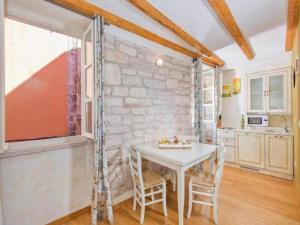 uma cozinha com uma mesa e cadeiras e uma parede de tijolos em Heritage Hotel Villa Valdibora em Rovinj