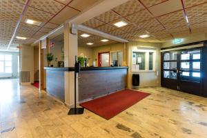 un vestíbulo de oficina con un mostrador y una alfombra roja en Hotell Tjamstan Malå, en Malå