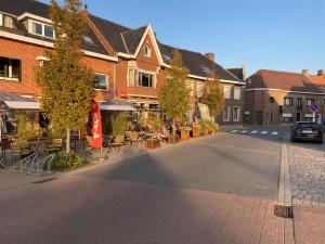 an empty street in a town with tables and chairs at 't Een en 't Ander in Tielt