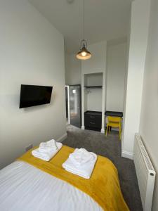 a bedroom with a bed with two towels on it at Marylebone by Pureserviced in Plymouth