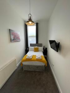 um quarto com uma cama com lençóis amarelos e uma janela em Marylebone by Pureserviced em Plymouth