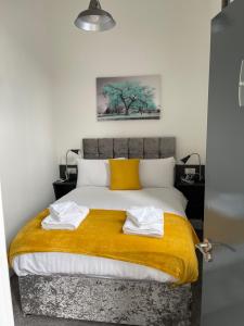 a bedroom with a large bed with a yellow blanket at Marylebone by Pureserviced in Plymouth