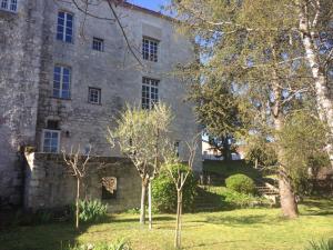 um velho edifício de pedra com árvores em frente em Château de Bouniagues em Bouniagues