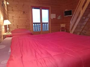 a bedroom with a pink bed and a balcony at Au Doubs Repos in Vorges-les-Pins