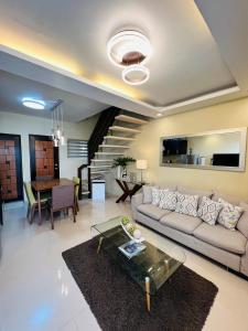 uma sala de estar com um sofá e uma mesa em Tagaytay Hampton Villa em Tagaytay