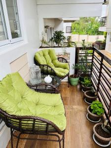 two wicker chairs and a table on a balcony with plants at Tagaytay Hampton Villa in Tagaytay