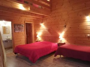 um quarto com 2 camas num chalé de madeira em Au Doubs Repos em Vorges-les-Pins