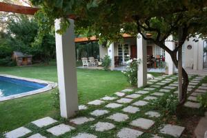 a backyard with a pool and a house at Daisy Tree Cottage in Oudtshoorn