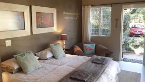 a bedroom with a bed and a large window at Daisy Tree Cottage in Oudtshoorn