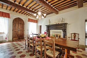 een eetkamer met een houten tafel en stoelen bij Villa Capolona by PosarelliVillas in Calbenzano