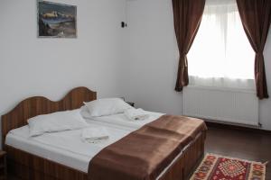 a bedroom with a bed and a window at Apartamente Gergely Apartmanok in Praid