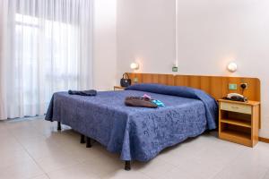 a bedroom with a bed with a blue blanket at Hotel Exclusive in Riccione