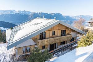 a house in the snow with mountains in the background at The Lodge Monte Bondone in Vason