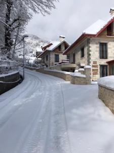 a snow covered street in front of a house at JOEN Village in Librazhd