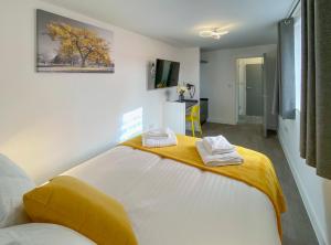 a bedroom with a large bed with two towels on it at Euston by Pureserviced in Plymouth