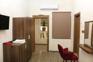 une salle d'attente avec une chaise rouge et un miroir dans l'établissement Grand Babil Otel, à Şanlıurfa