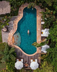 una vista aérea de un hombre en una piscina con sombrillas en Pousada Mangabeiras, en Isla de Boipeba