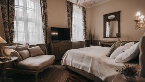 1 dormitorio con cama, sofá y TV en Room42 - Suites & Apartments, en Esztergom