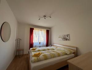 Schlafzimmer mit einem Bett und einem Fenster mit roten Vorhängen in der Unterkunft Brissago: Casa Collinetta H in Brissago