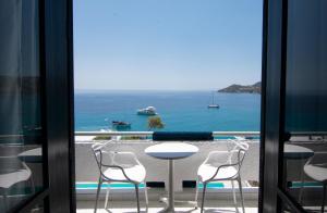 a view of the ocean from a balcony with a table and chairs at Apollo Resort in Agia Marina Aegina