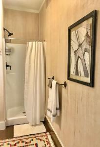 ein Bad mit einem Duschvorhang und einem Spiegel in der Unterkunft THE FARMHOUSE private apartments in Eufaula