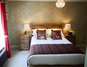 a bedroom with a bed with two night stands and two lamps at Wykeham Arms in Winchester