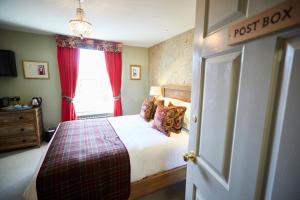 a post box bedroom with a bed and a window at Wykeham Arms in Winchester
