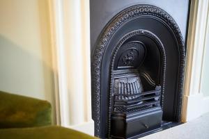 a black fireplace in the corner of a room at Wykeham Arms in Winchester