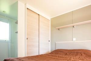 a bedroom with a bed and a wall of closets at Mobile Home OuiReves 513 facing the Mediterranean in Lattes