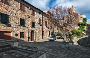 een auto geparkeerd voor een stenen gebouw bij B&B Da Nada Locanda Toscana in Roccatederighi