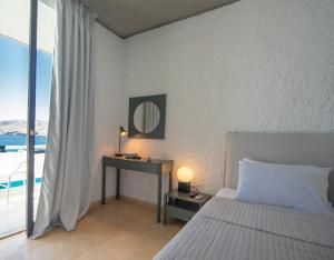 a bedroom with a bed and a table with a mirror at Apollo Resort in Agia Marina Aegina