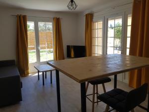 salon z drewnianym stołem i krzesłami w obiekcie Domaines des confines w mieście Monteux