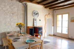 a dining room with a table and chairs and a fireplace at Le Domaine des Eléphants - SPA EN OPTION - 900m du Zoo in La Cévrie
